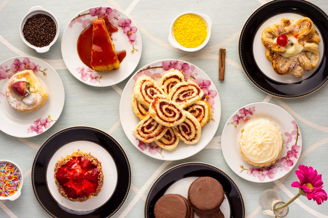 An assortment of mouthwatering pastries displayed on floral plates for a delightful treat.