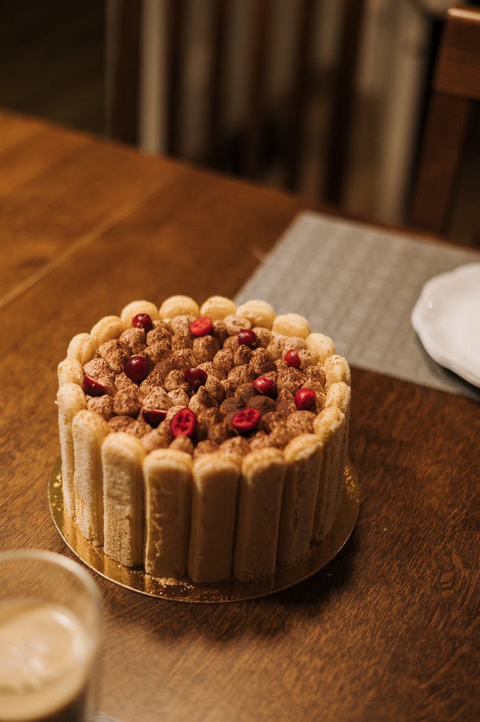 Mouthwatering homemade tiramisu cake topped with fresh raspberries, perfect for dessert lovers.