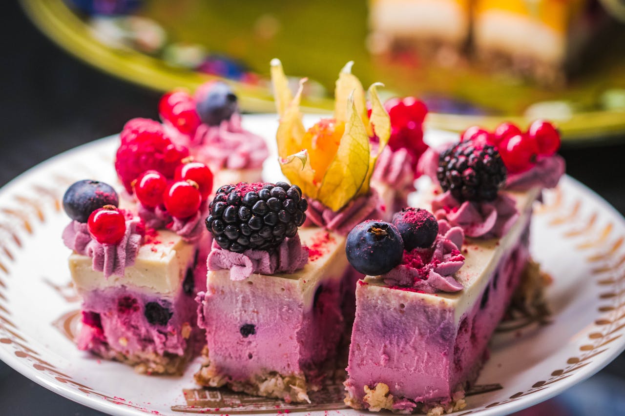 Tantalizing slices of mixed berry cheesecake topped with fresh blackberries, red currants, and blueberries.